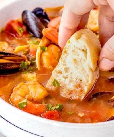 Dunking bread in a bowl of Cioppino