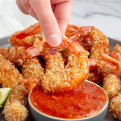 Dipping coconut shrimp in sweet chili and apricot sauce.