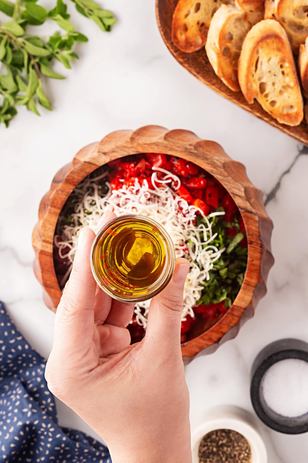 This Best Tomato Bruschetta recipe will have you making it all year round. The flavors are perfectly balanced and one that I get rave reviews from. Adding olive oil.