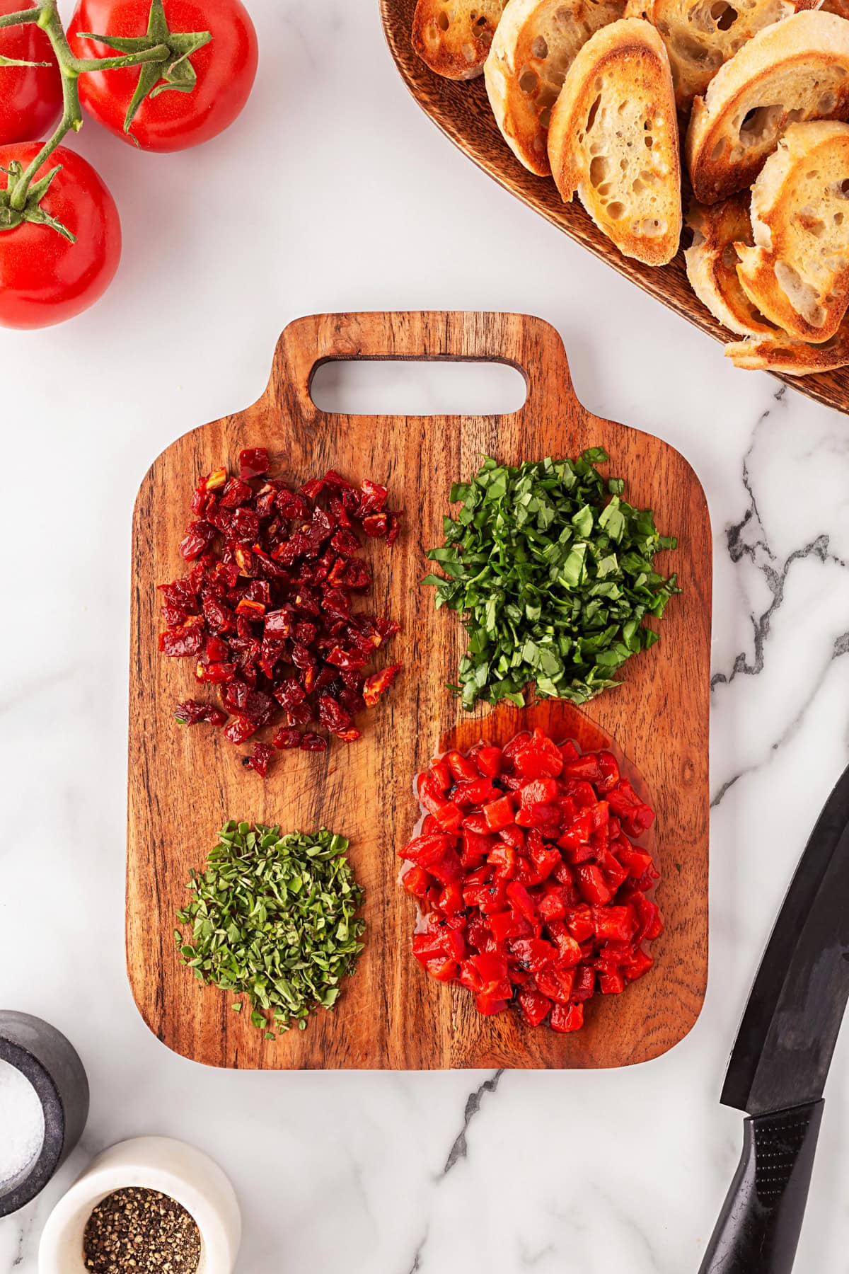 This Best Tomato Bruschetta recipe will have you making it all year round. The flavors are perfectly balanced and one that I get rave reviews from. Herbs and tomatoes chopped.