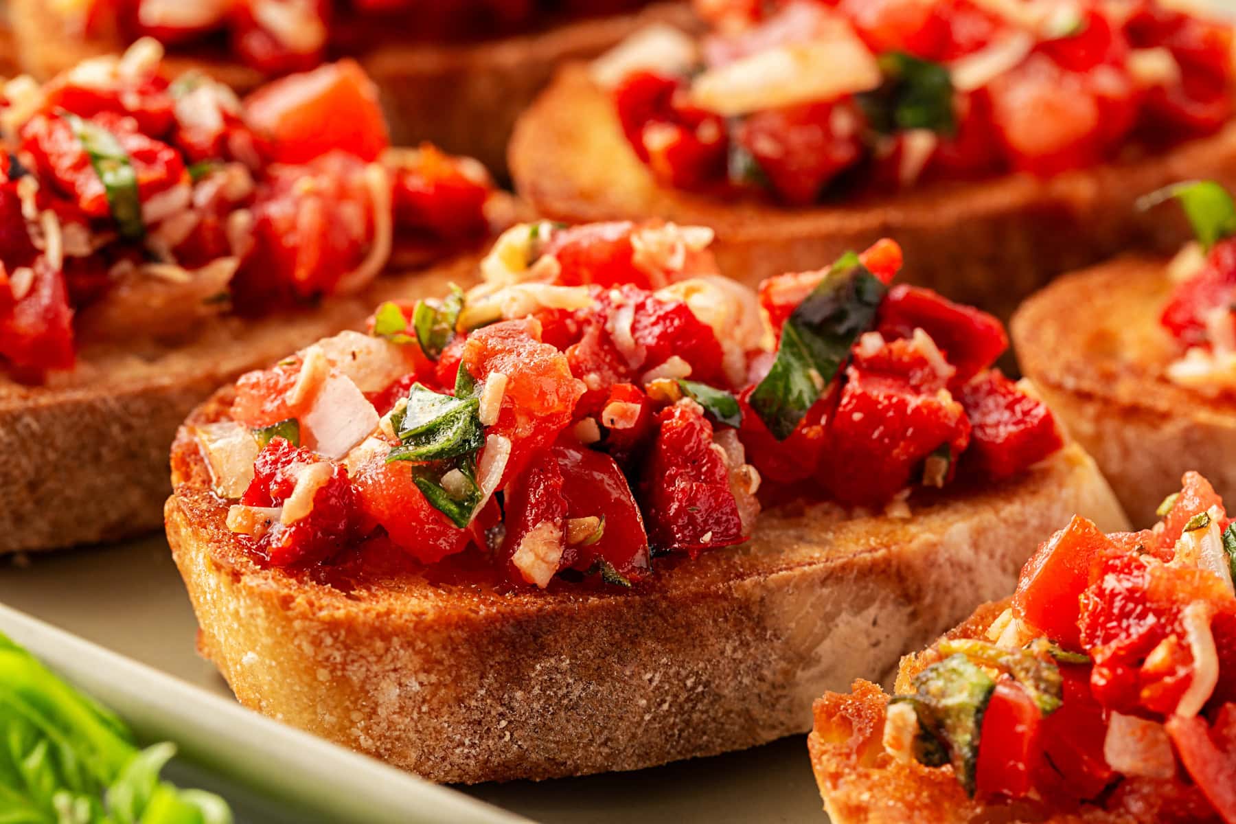 This Best Tomato Bruschetta recipe will have you making it all year round. The flavors are perfectly balanced and one that I get rave reviews from. Horizontal close-up of tomato bruschetta.