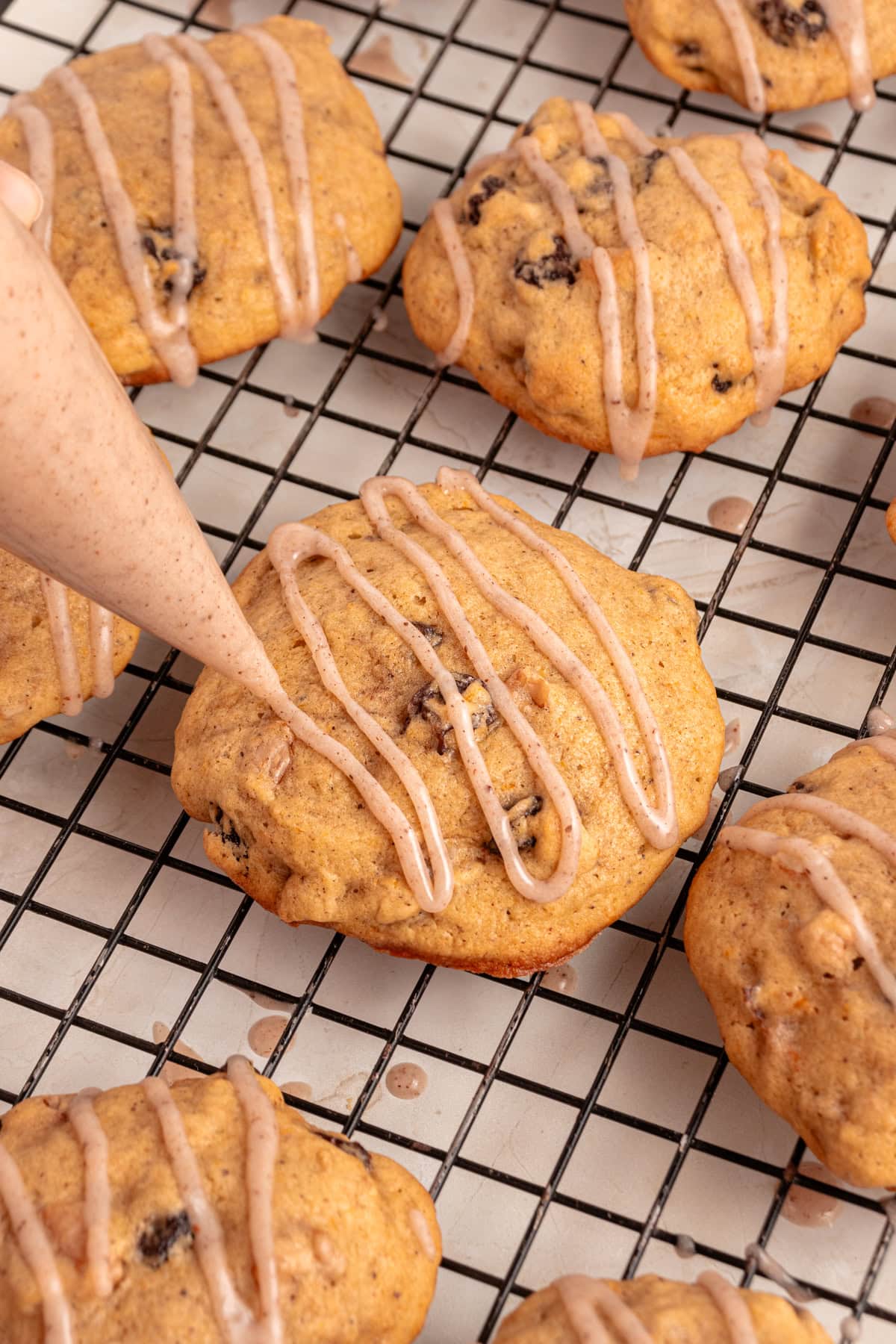 Adding cinnamon glaze to the pumpkin cookies.