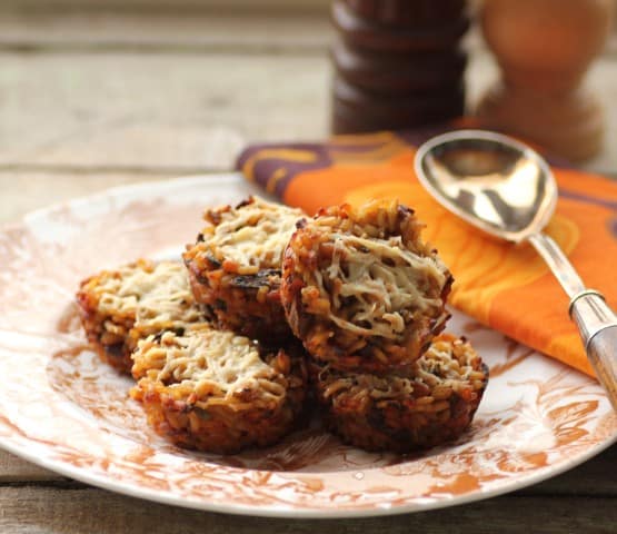 Vegetarian Mushroom Stuffing Cups stacked on a china plate with a serving spoon