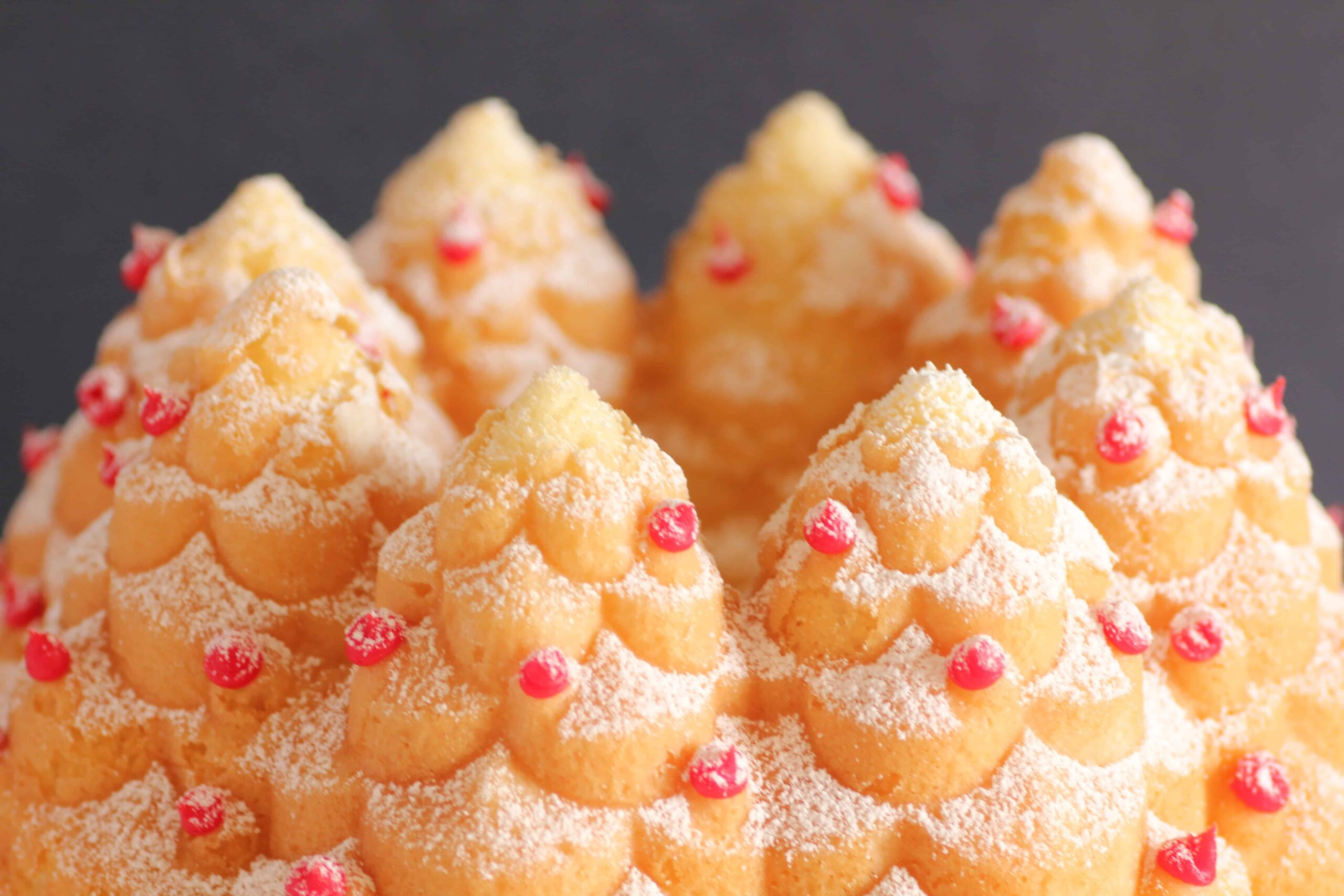 Holiday Tree Cake dusted with powdered sugar and decorated with red lcing dots.