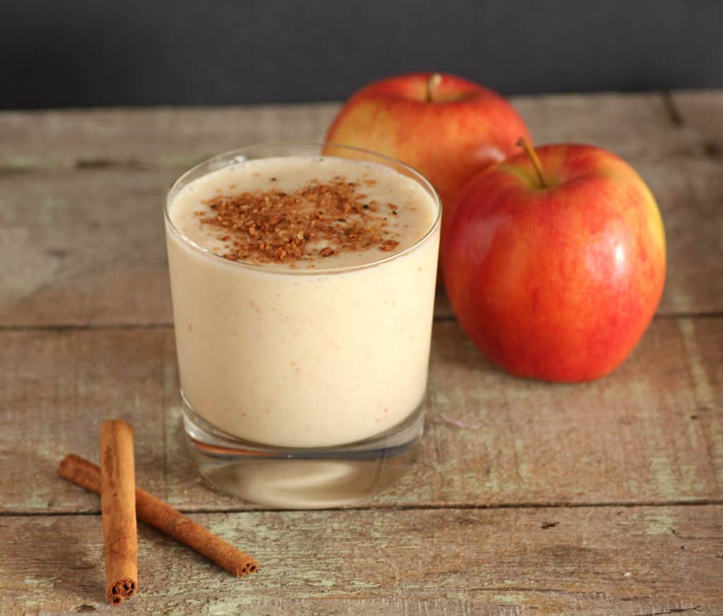 Apple Pie Smoothie with 3 apples and 2 cinnamon stickes on a wooden board
