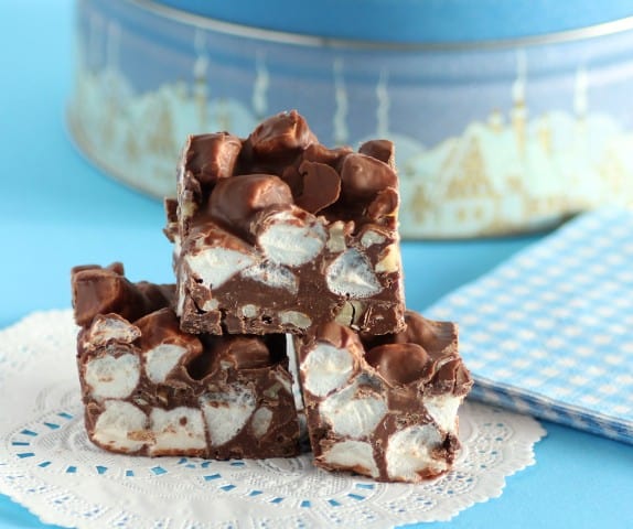 3 squares of rocky road chocolate stacked on a white doily