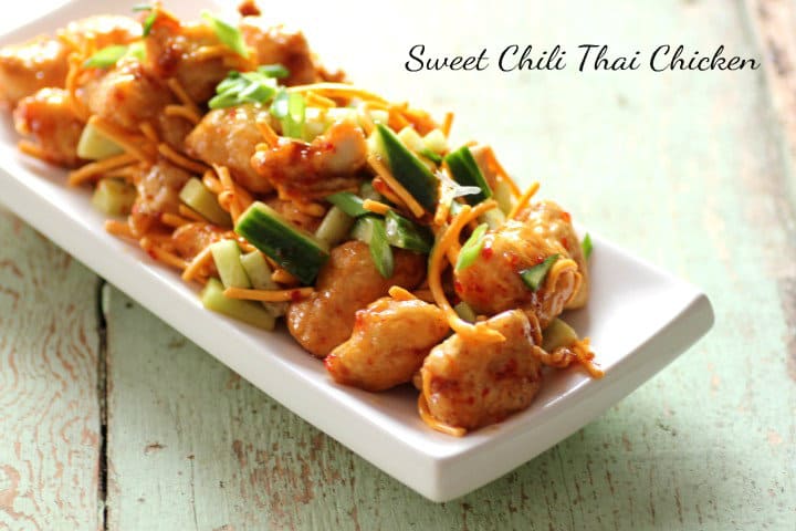 Sweet Chili Thai Chicken ona white serving platter sitting on a wooden board