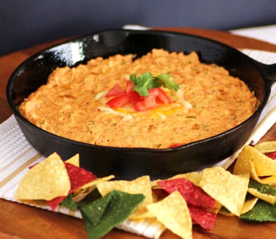 Chorizo Cheese Dip in a cast Iron Skillet with colourful tortilla chips around the pan