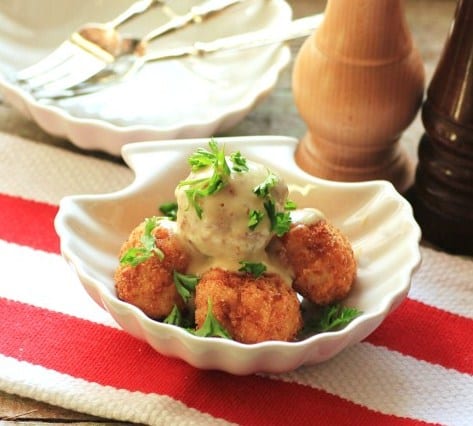 Asiago Stuffed Aranchini with tuffle cream sauce in a white clam shell shaped bowl