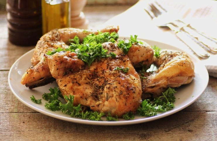 Herbs De Provence Roast Chicken on a white serving plate with parsley garnish