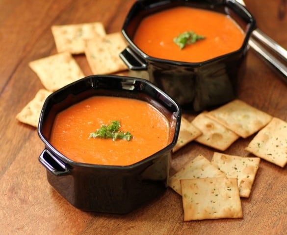 Tomato Soup in black bowls with crackers