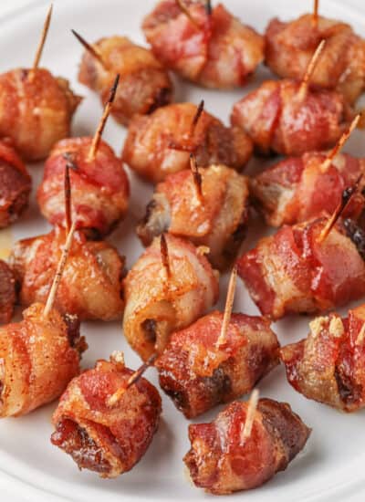 Bacon-Wrapped Dates on a white plate.