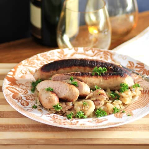 Coddle on a white and gold china plate sitting on a wooden board