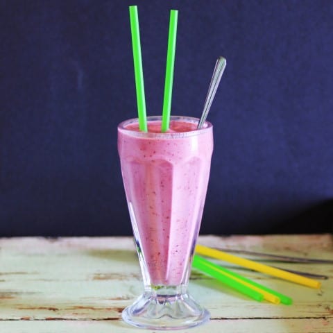 Lemon Blackberry Smoothie in a tall soda glass with 2 straws and a long spoon