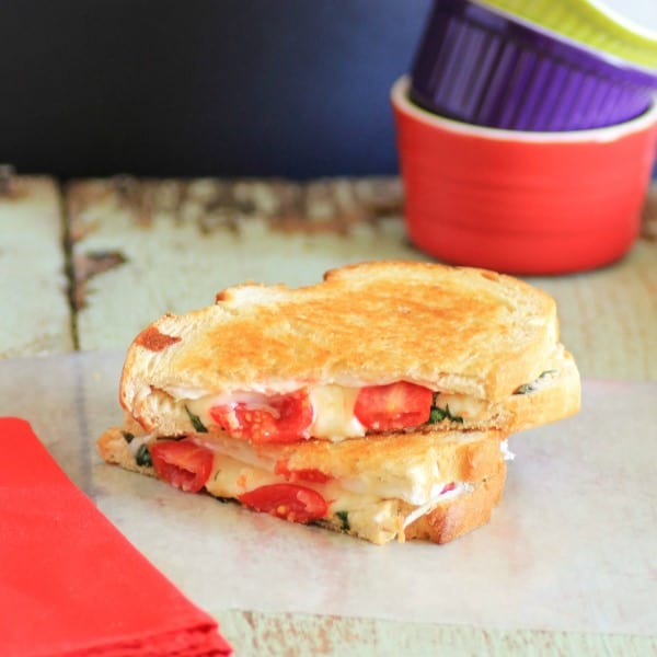 French Brie Grilled Cheese Sandwich sliced in half and stacked on wooden board