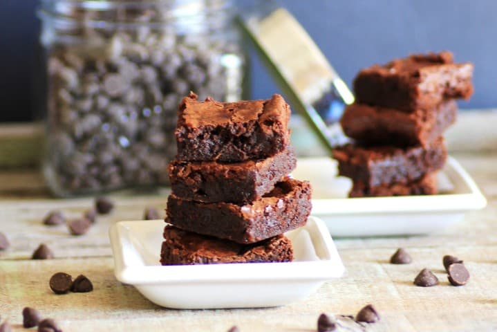 Fudgy Carob Brownies squares stacked on top of each other on a small white plate