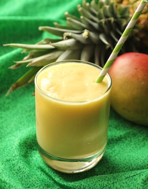 Mango Pineapple Smoothie in a glass with a straw.
