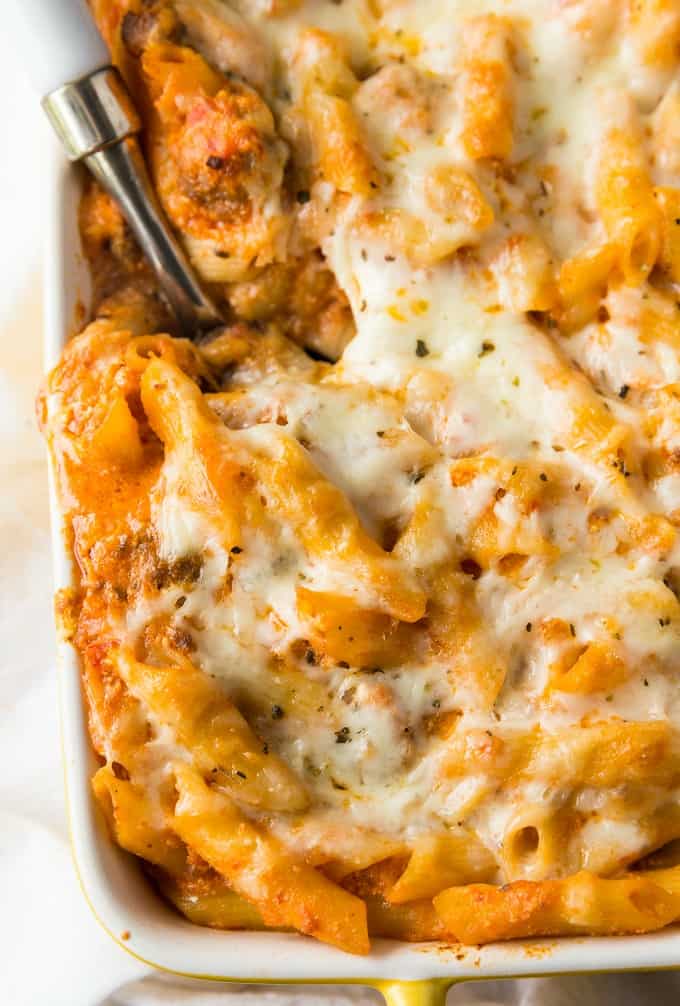 Penne a la vodka in a casserole dish with a serving spoon