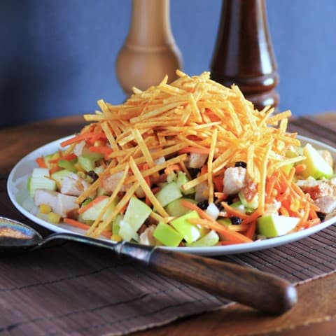 Salpicao Brazilian Salad on a white plate witha serving spoon beside the plate