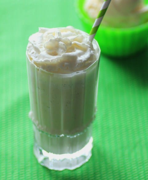 Vanilla Bean Frappuccino in a tall glass with a green and white straw