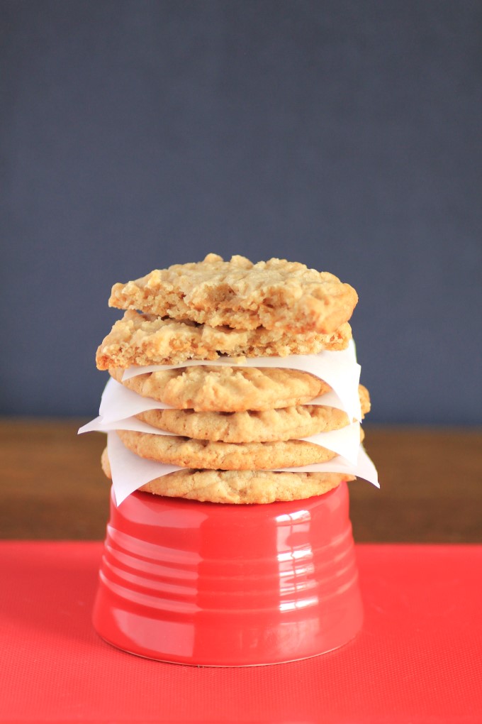 Peanut butter cookies stacked on a red bowl with paper in between