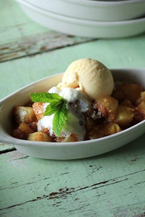 Pineapple Crisp in a oval serving dish with a scoop of ice cream on top