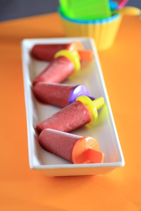 Strawberry Lime Ice Pops laying on a white platter