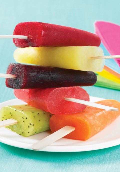 Various ice pops stacked on a white plate