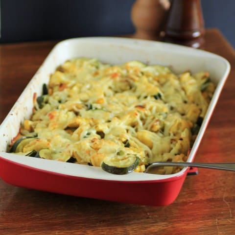 Abuela's Calabasita casserole in a red and white dish with a serving spoon