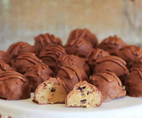 Chocolate Chip Cookie Dough Truffles on a white platter with one cut in half 
