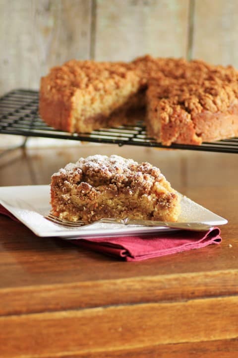 Slice of maple syrup pecan coffee cake on a white plate 