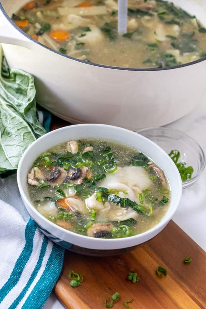 Bowl of Wor Wonton Soup with a pot of soup behind