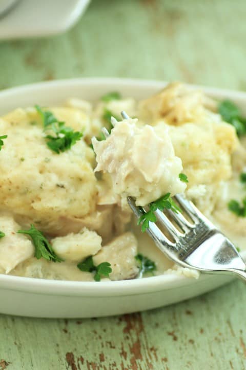 Quick Chicken and Dumplings on a fork with a white oval dish in the background