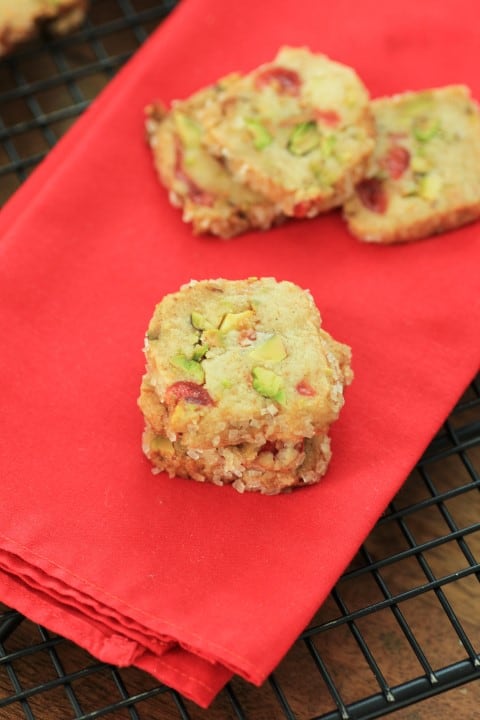 Cherry Pistachio Ice Box Cookies on a red napkin on a cooking rack. 