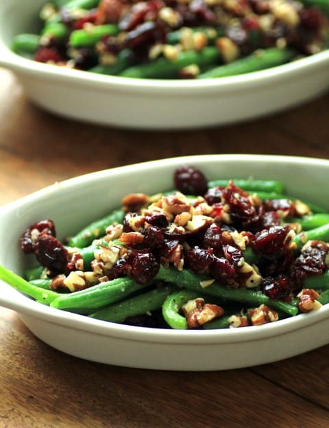 Green Beans with Pecans and Cranberries in a white oval serving dish