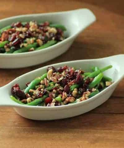 Green Beans with Pecans and Cranberries in oval serving dishes