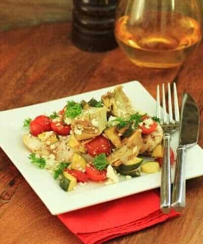 Mediterranean Chicken Bake on a white plate with a knife and fork