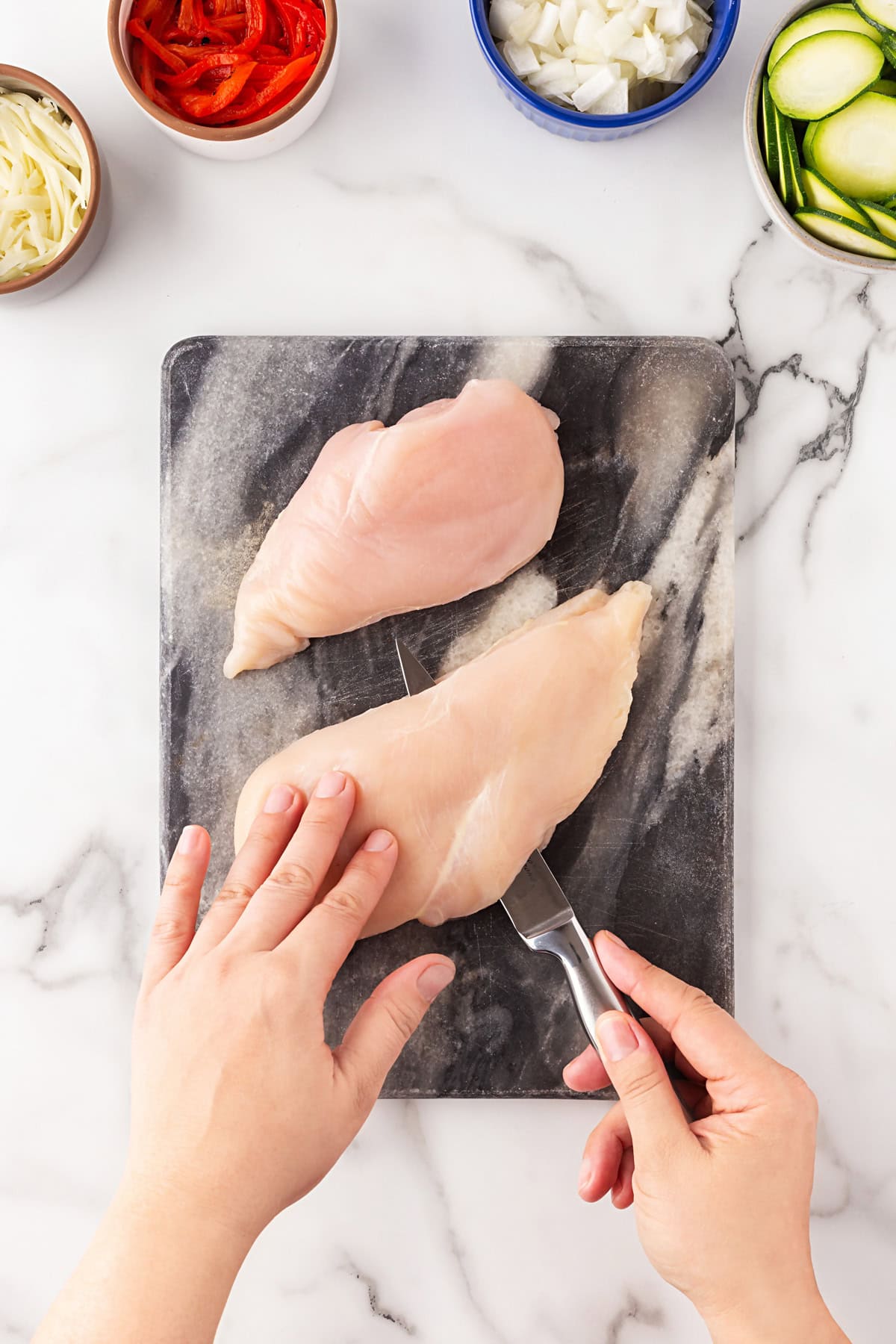 Slicing chicken horizontally. 