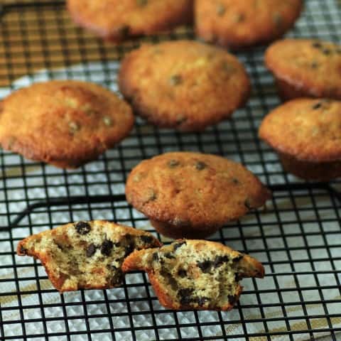 Mini Banana Chocolate Chip Muffins on a wire cooling rack with one broken in half