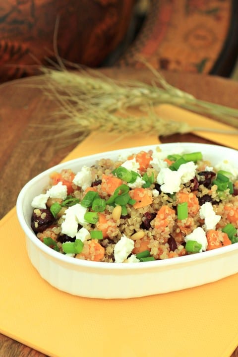 Sweet Potato and Quinoa Salad in an white oval dish on a yellow cutting board