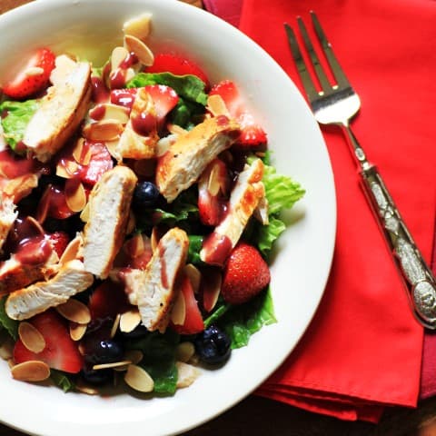 Wendy's Copycat Berry Almond Chicken Salad in a white bowl with a fork on a red napkin