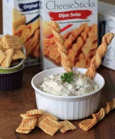 Caramelized Onion and Bacon Dip in a small white bowl with bread sticks for dipping