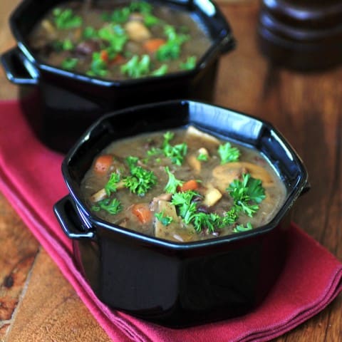 Beef, Wine and Mushroom Soup in black serving bowls on a red napkin