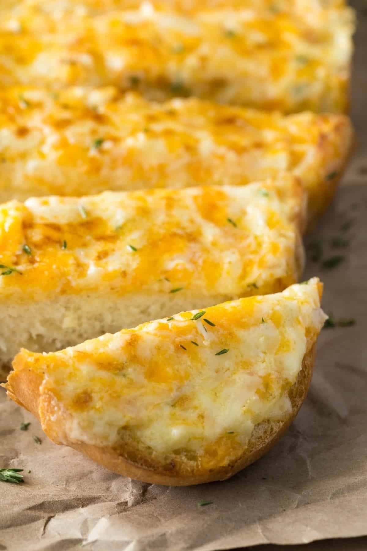 Showing a close-up of the first cut of the cheesy bread sliced. 