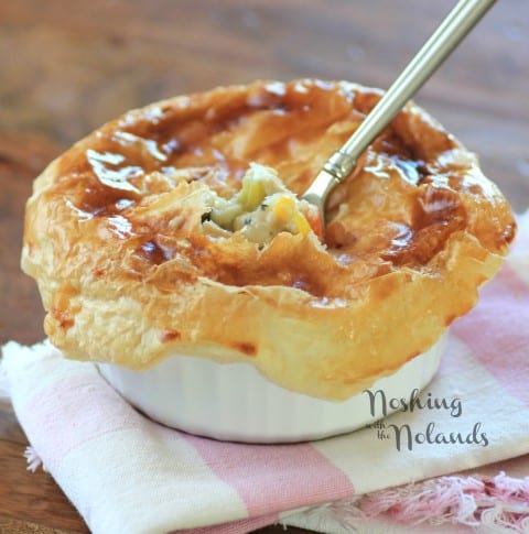 Individual chicken pot pie with a fork in the top sitting on a white and pink napkin