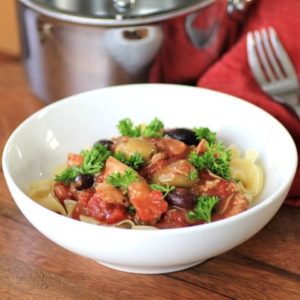 Slow Cooker Chicken Cacciatore in a white bowl with parsley for garnish