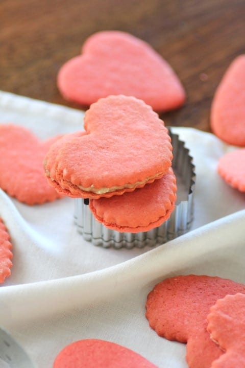 Pink Valentine Heart Cookies on a white table cloth and wooden board