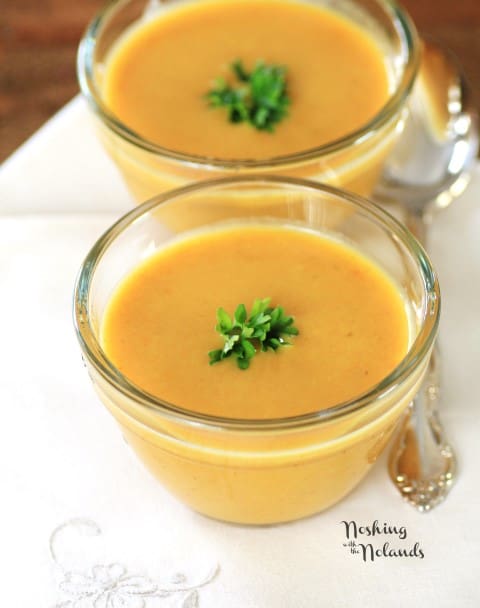 Carrot Curry Soup in small glass bowls garnished with parsley