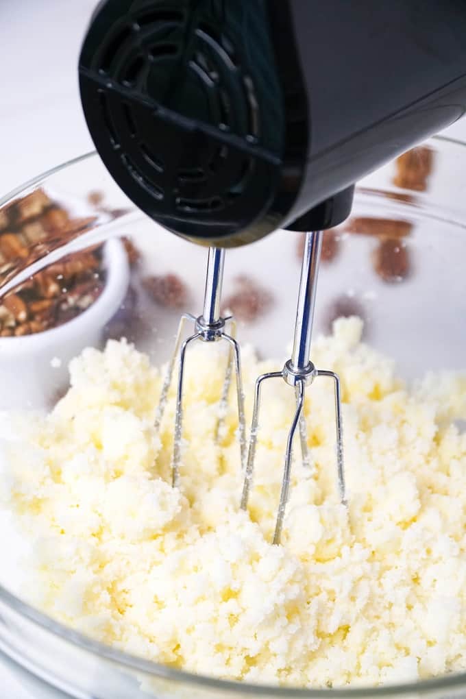 Using a hand mixer to fluff butter and sugar