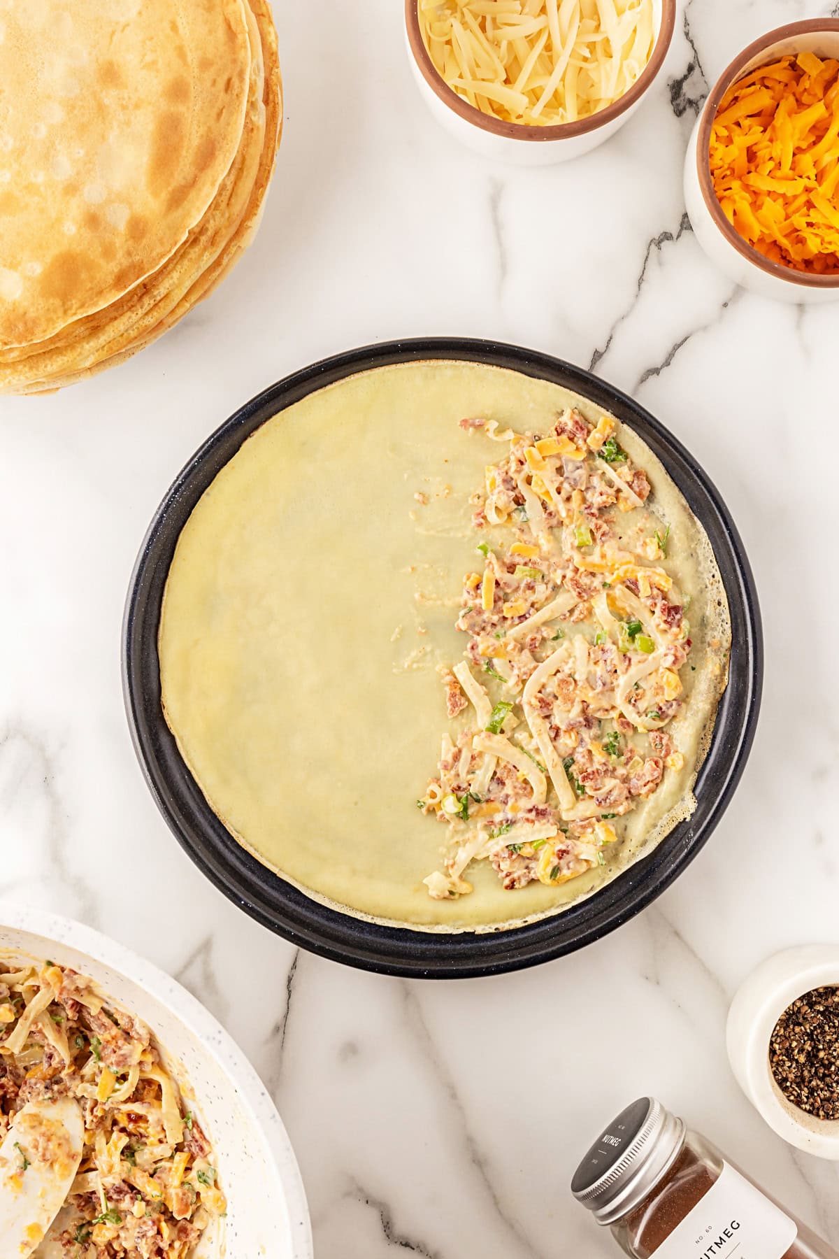 This recipe for Crepes Lorraine is a time-honored treasure that I have been making for over 40 years. Friends and family love this recipe, and I am thrilled to offer it to you also. Filling spread on half the crepe.